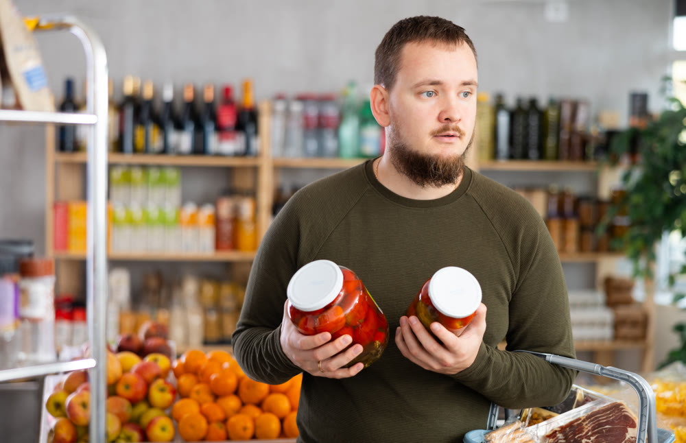 Man holds canned tomatoes in his hands