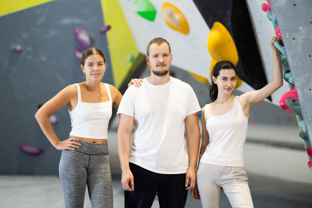 Portrait of three athletic people in climbing gym