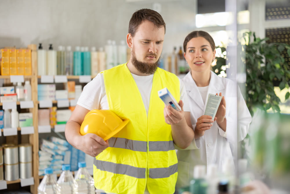 Laboring man builder buys gel for burns at pharmacy, consulting with girl pharmacist
