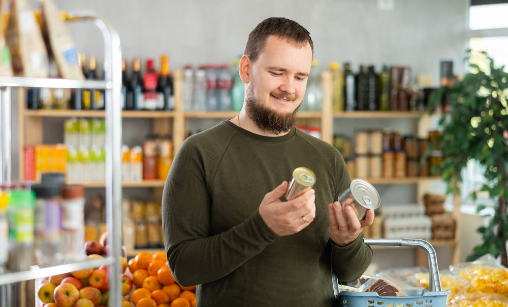 man chooses canned food.