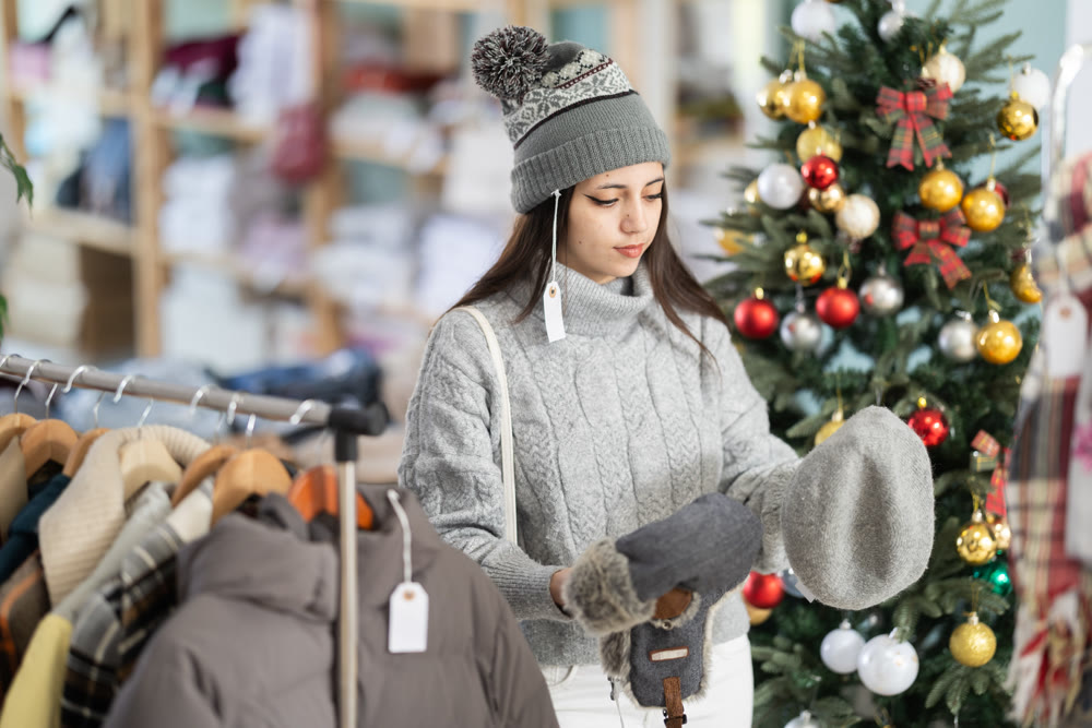 Young woman tries on hat in store