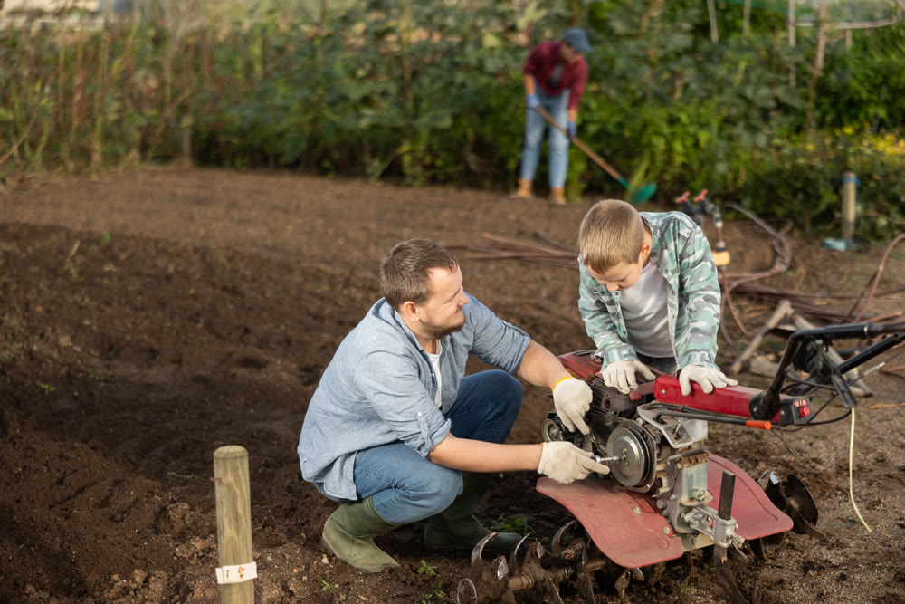 Man and his son are repairing garden equipment