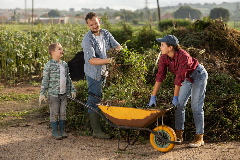 Family of farmers puts branches in a cart