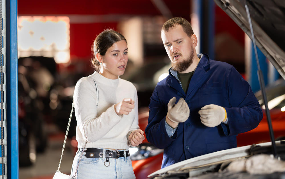 Woman Consulting Male Mechanic About Car