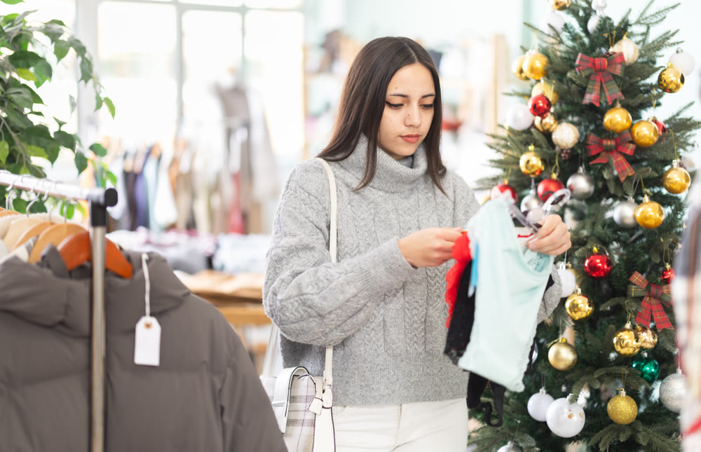 Woman holding hangers with panties in her hands in a store