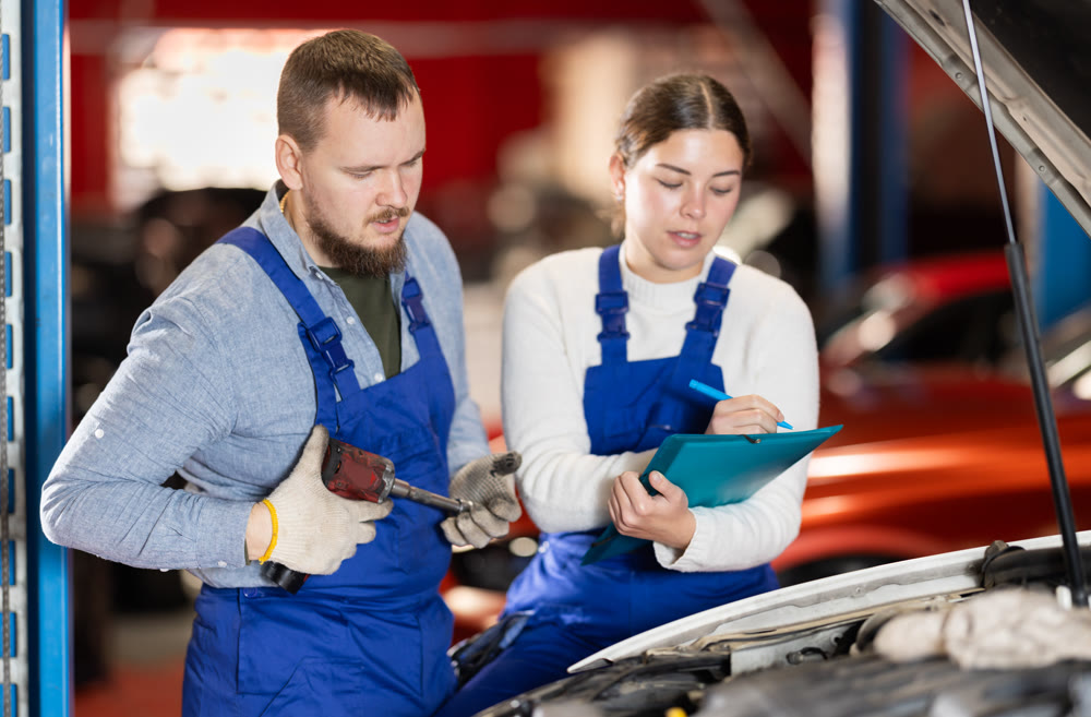 Car service workers discuss the process of repairing a car