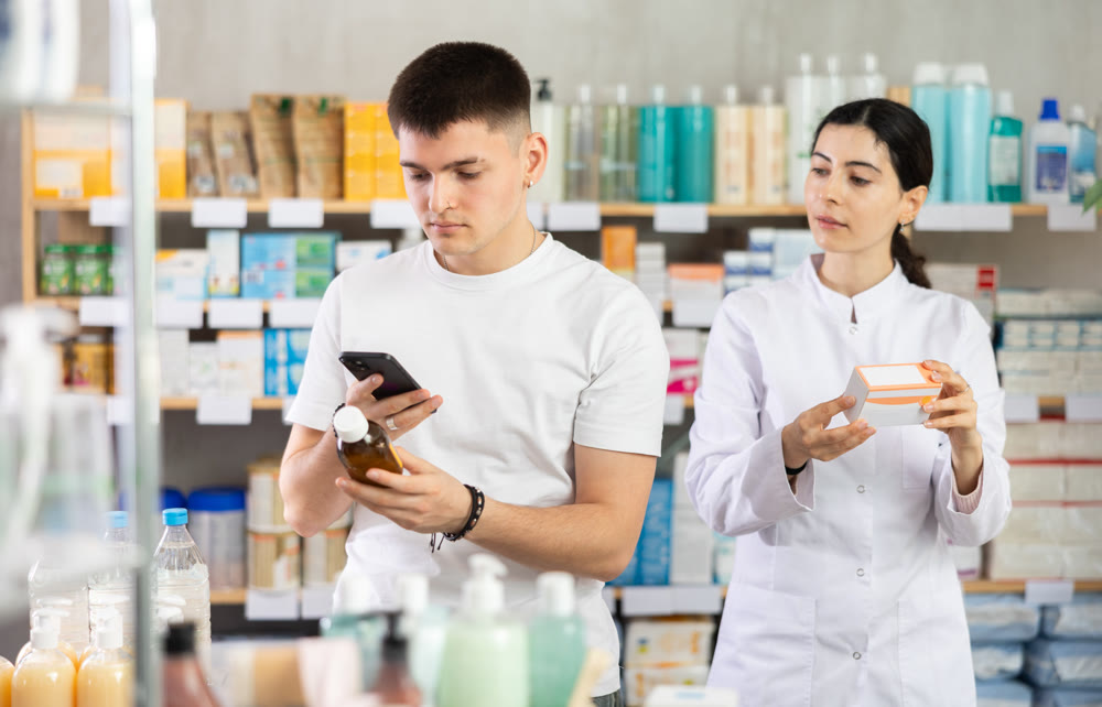Man buyer scans syrup qr code with woman pharmacist