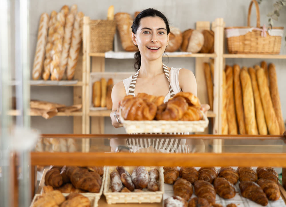 Young woman seller with basket of croissants