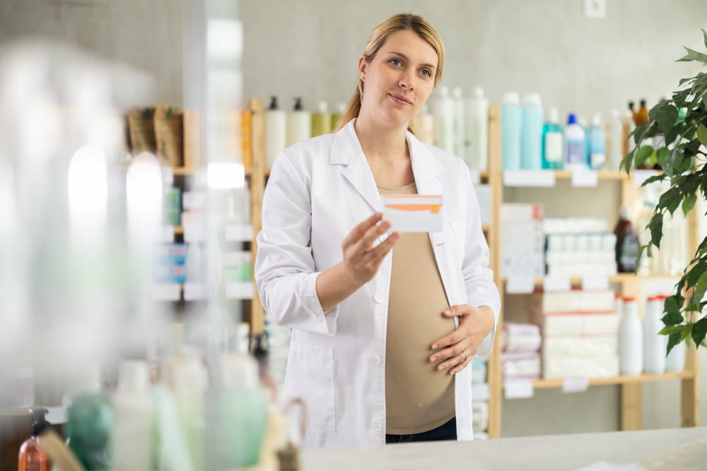 Pregnant pharmacist offering preparation in box