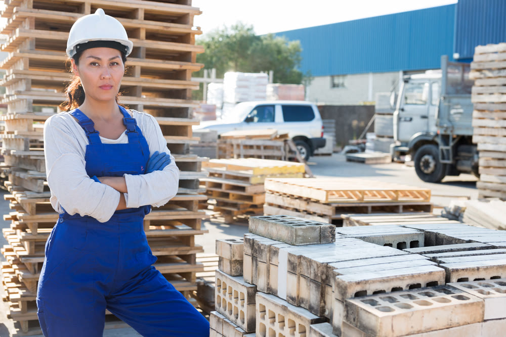 Portrait of female worker at warehouse of building materials in open air