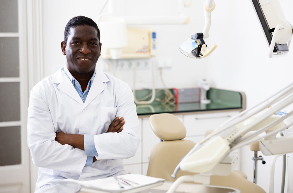 Smiling african american dentist standing in dental office