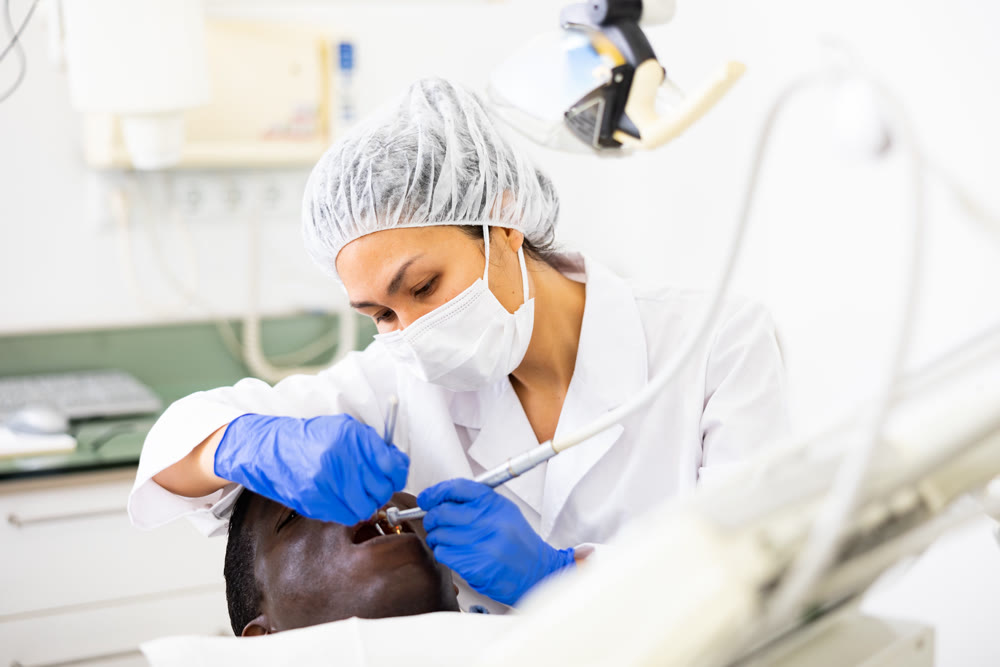 Dentist examining oral cavity of man in dental clinic