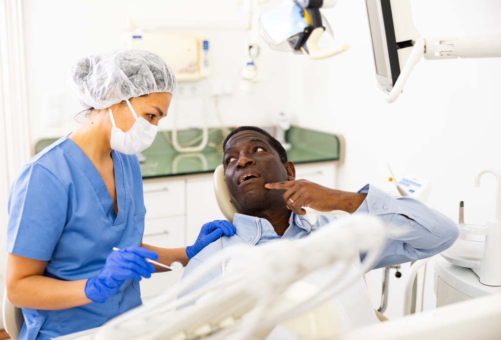 Patient points with his finger which tooth hurts. Complains to the dentist about toothache