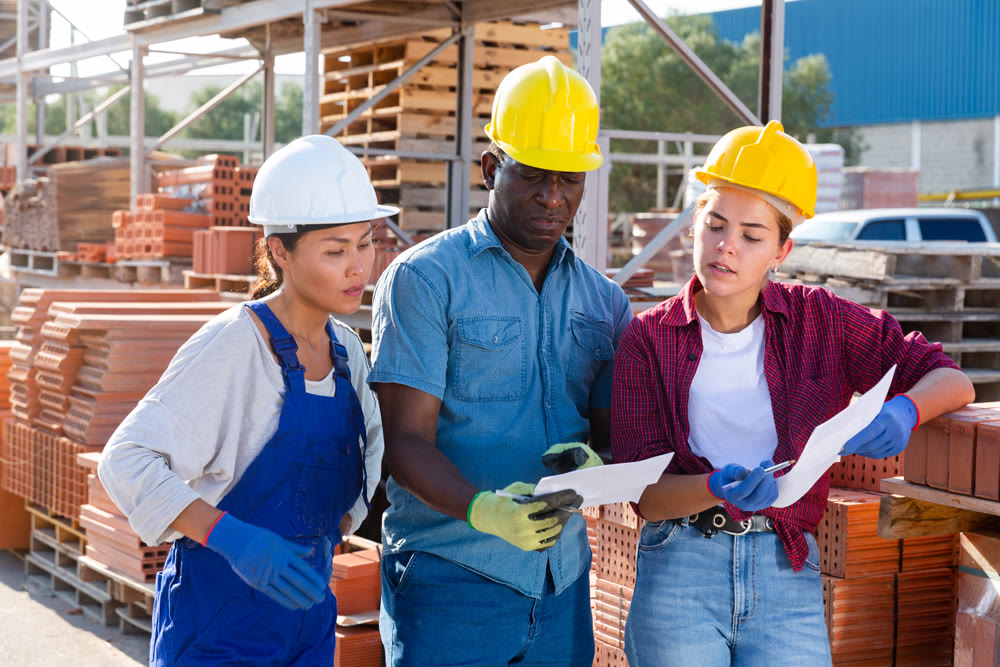 Managers and workers are discussing work plan on site of an open-air construction store