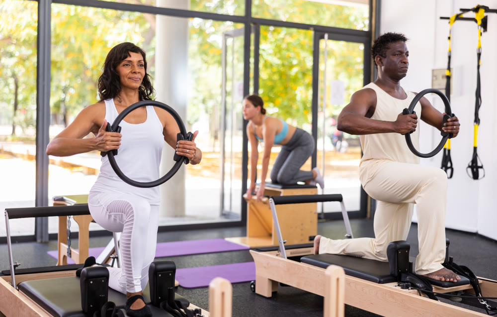 Multiracial group of people doing exercises during pilates training