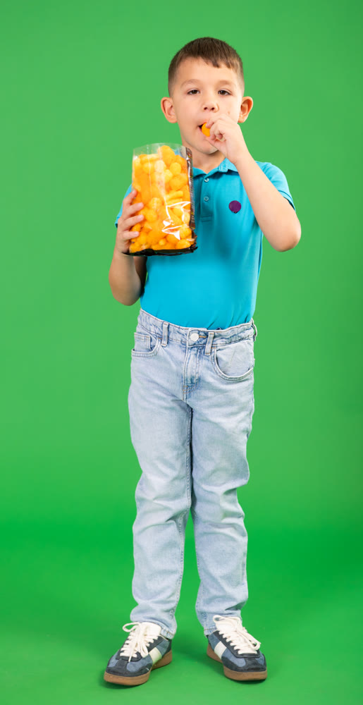 Boy in jeans with corn sticks package, sweet snack