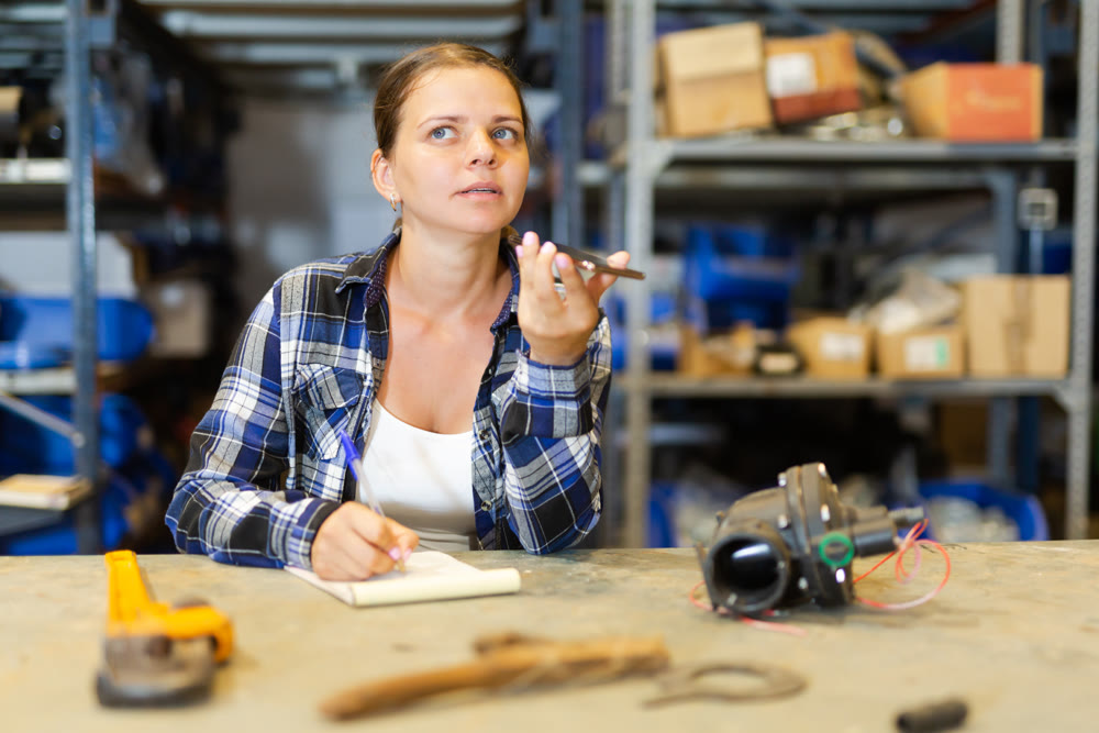 Woman store warehouse employee talking on mobile phone with customer closeup