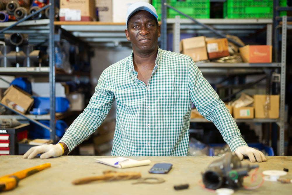Warehouse worker standing at table in workshop