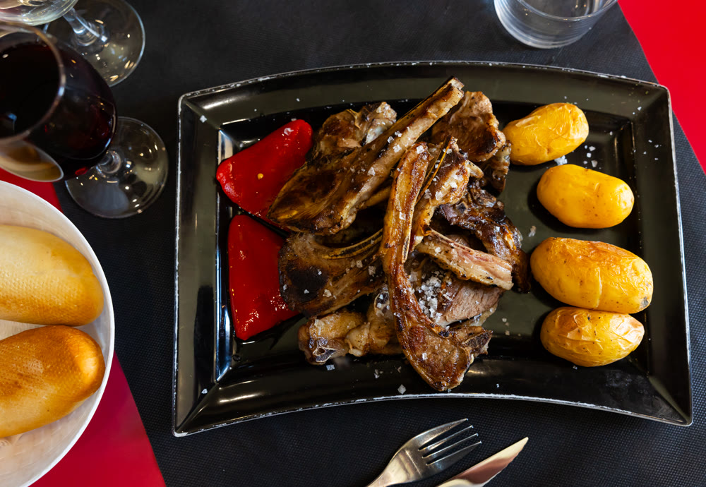 Fried lamb served with potatoes and peppers