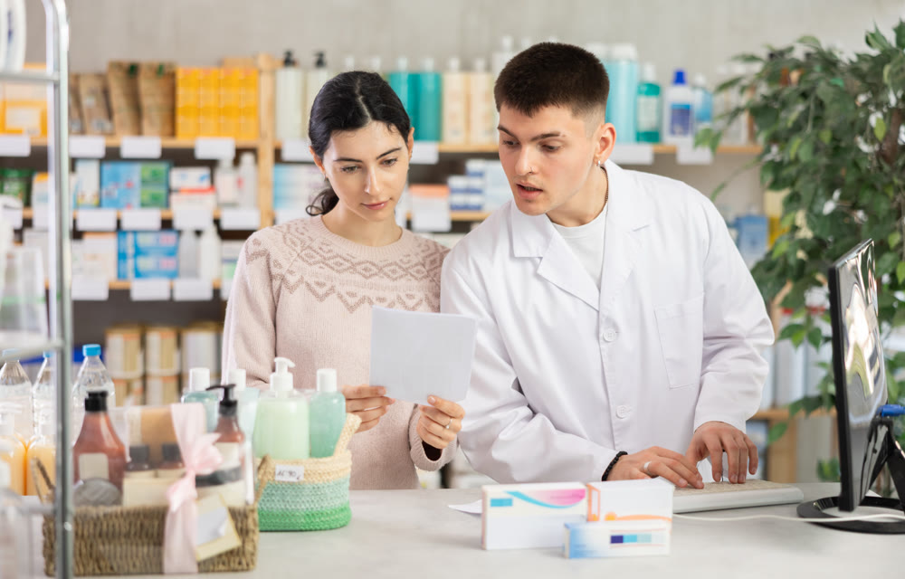 Man pharmacist looking for prescription on computer for buyer