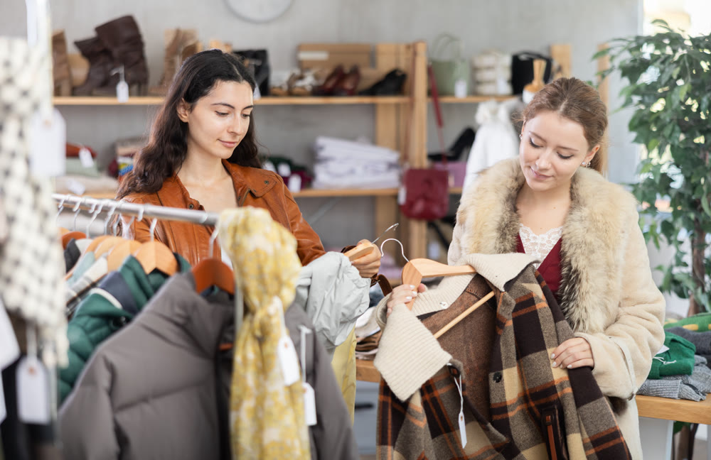 Two girls choose outerwear for the autumn winter season