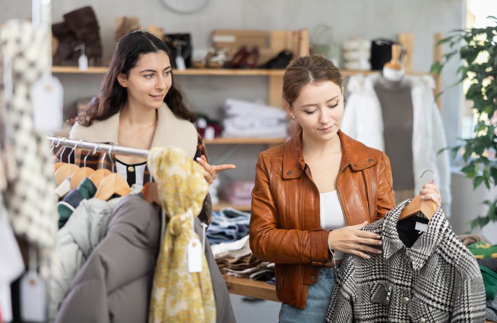 Two girls choose outerwear for the autumn winter season
