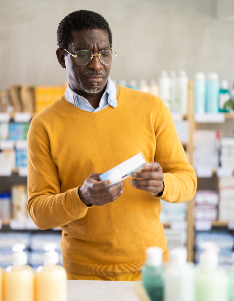 African man choose buy pain relief ointment at pharmacy