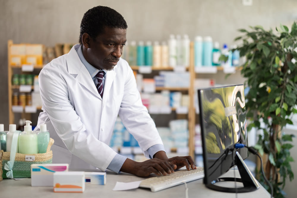 Pharmacist processing supply orders through pharmacy system