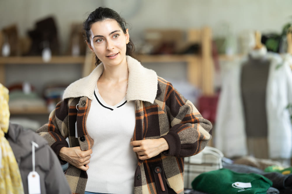 Armenian woman trying on a plaid jacket in a store
