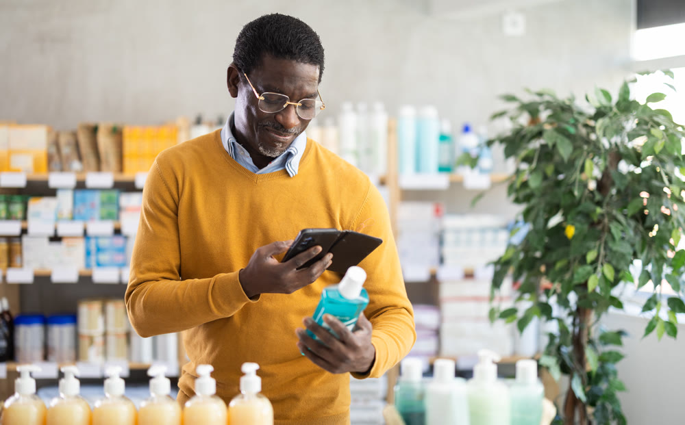 Woman in autumn clothes scans code on medicinal mouthwash to check expiration date