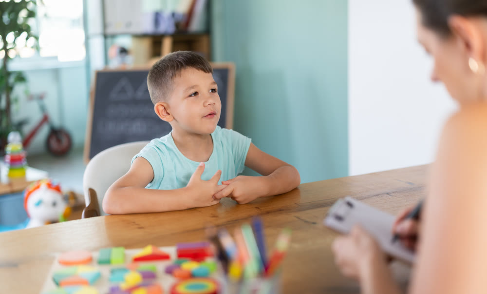 Little boy talking to child psychologist during survey