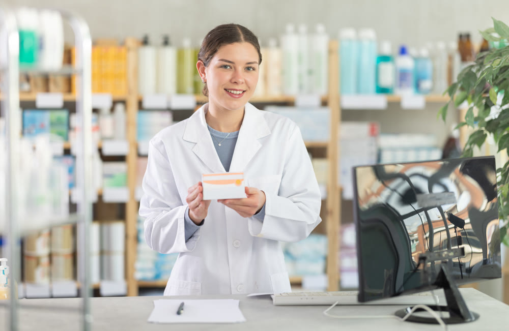 Young female pharmacist offering preparation in box