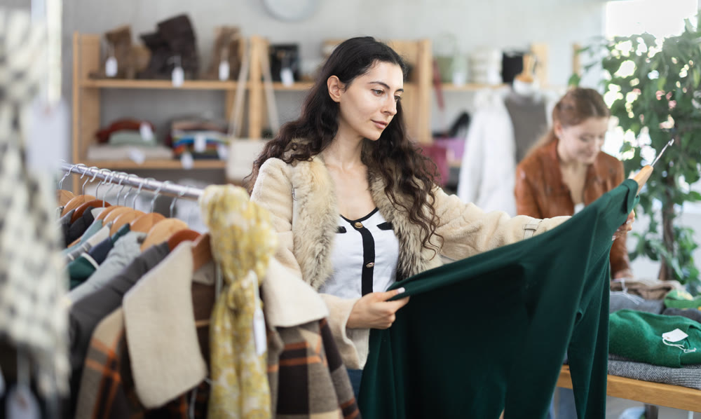 Girl chooses warm warm dress in clothing store