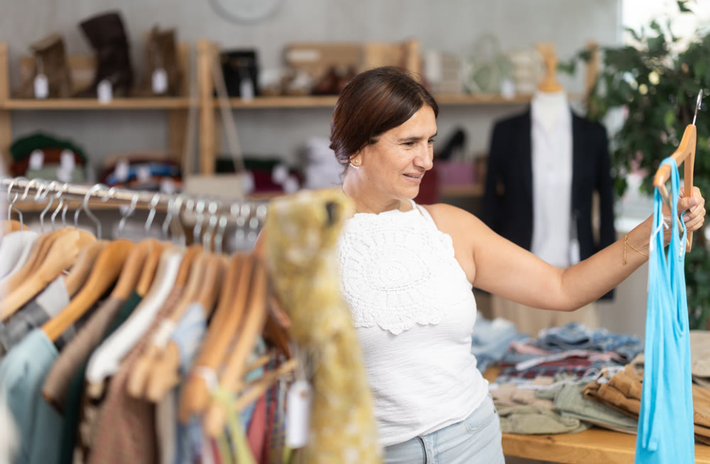 Latin woman customer turn over and choose something summer cloth in store,