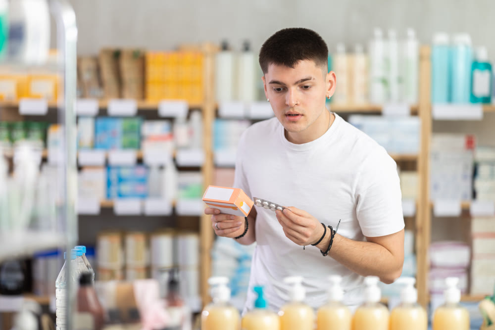 Young man buys pills at pharmacy