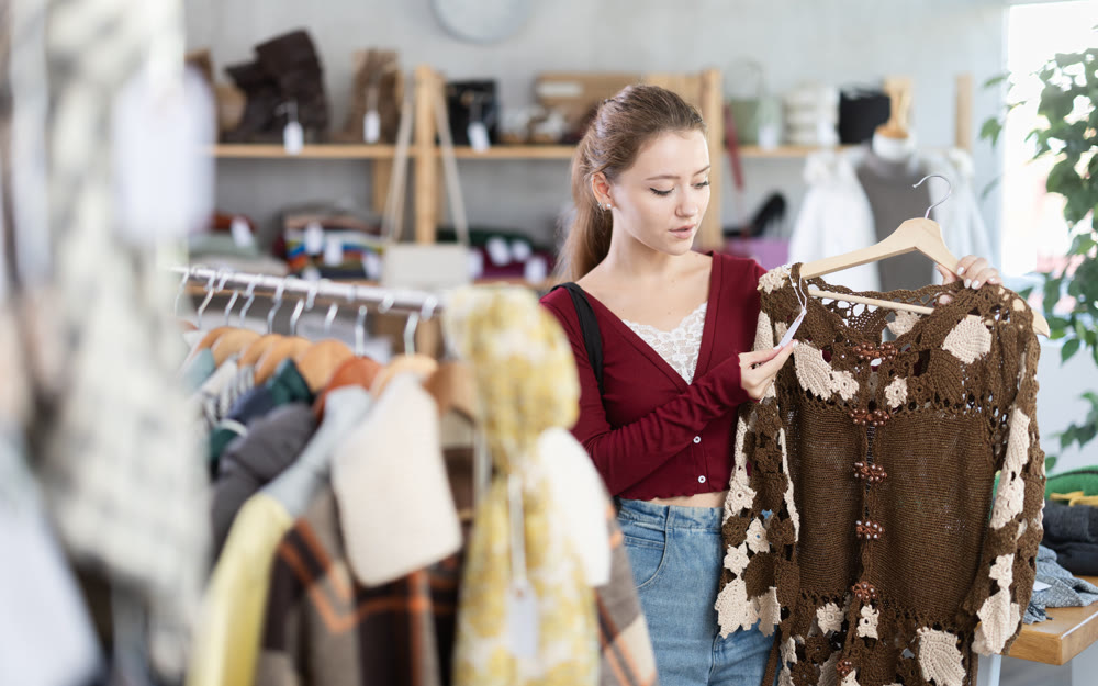 Girl chooses warm warm dress in clothing store