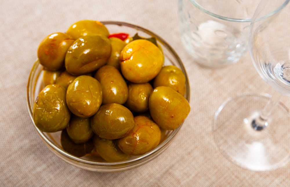 Green olives with pits served in bowl