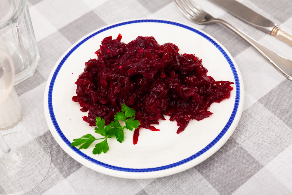 Traditional salad of Russian cuisine from boiled grated beetroot, decorated with sprig of parsley