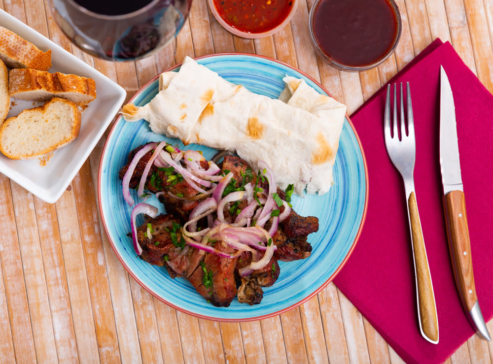 Grilled pork meat shashlik with marinated onion