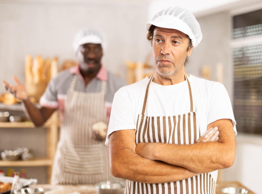 Two male bakers quarreling in workshop