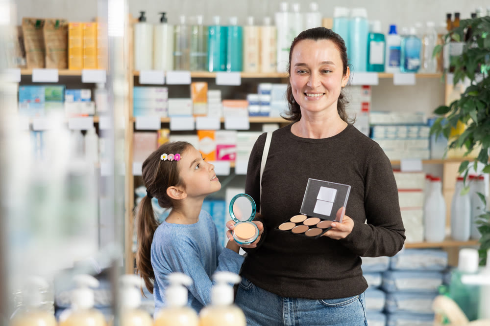 woman and daughter choose cosmetics in a pharmacy near the shelves