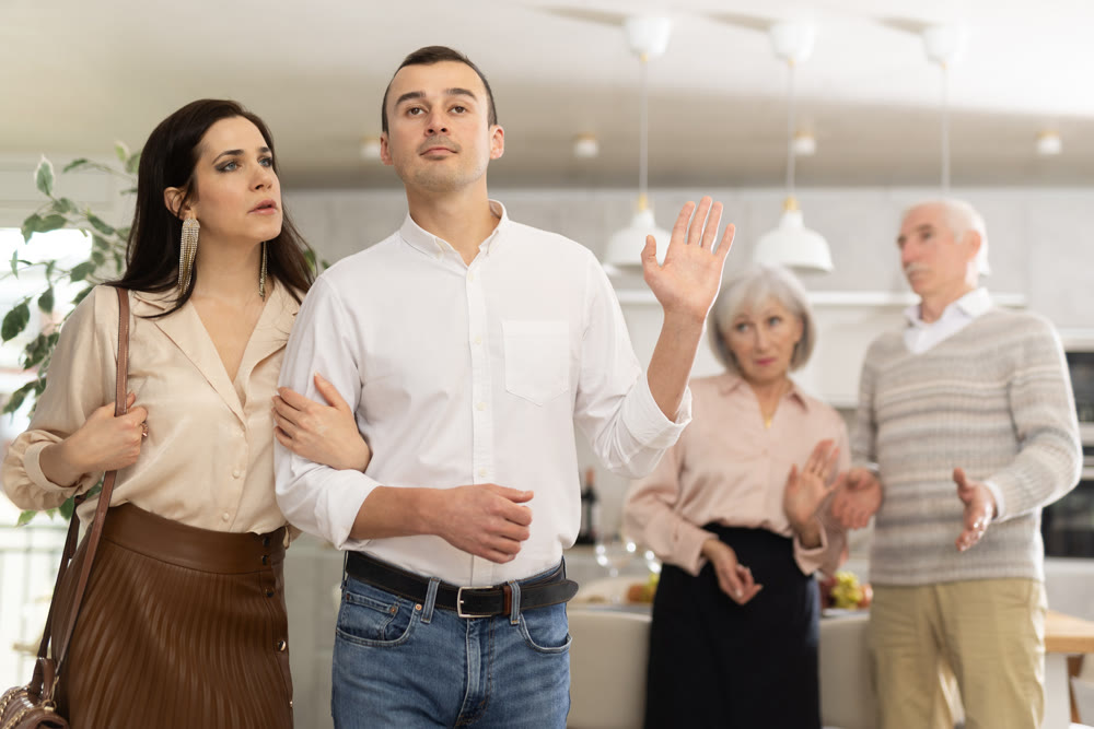 Disgruntled elderly parents accompany their son and daughter-in-law.