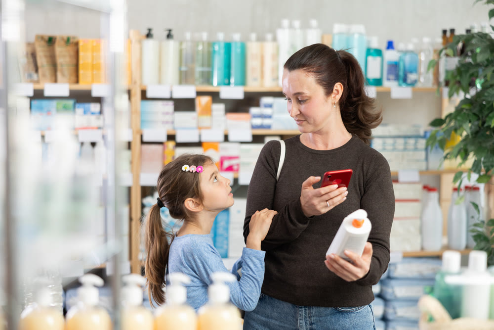 woman with a child pays for purchases using a QR code at a pharmacy