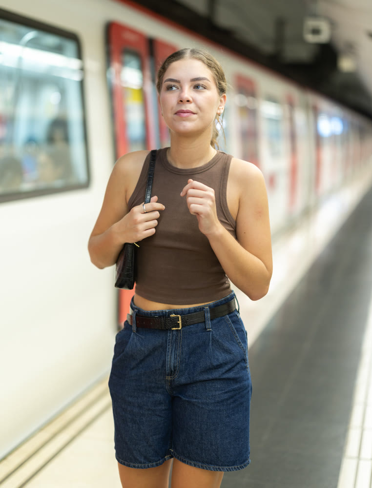 Young woman at metro station is waiting for train