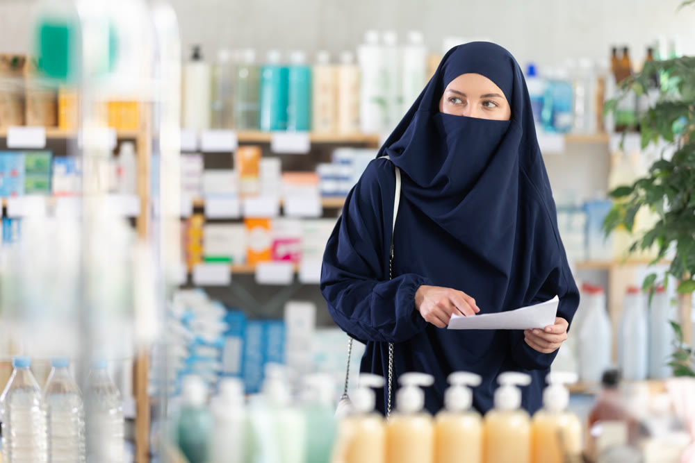 Young woman in hijab chooses prescription medications