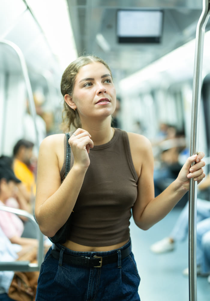 Young woman standing inside moving subway car