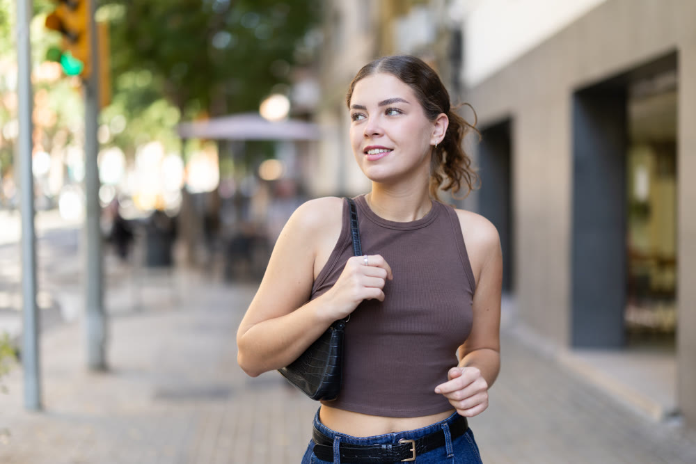Young woman walks along city street