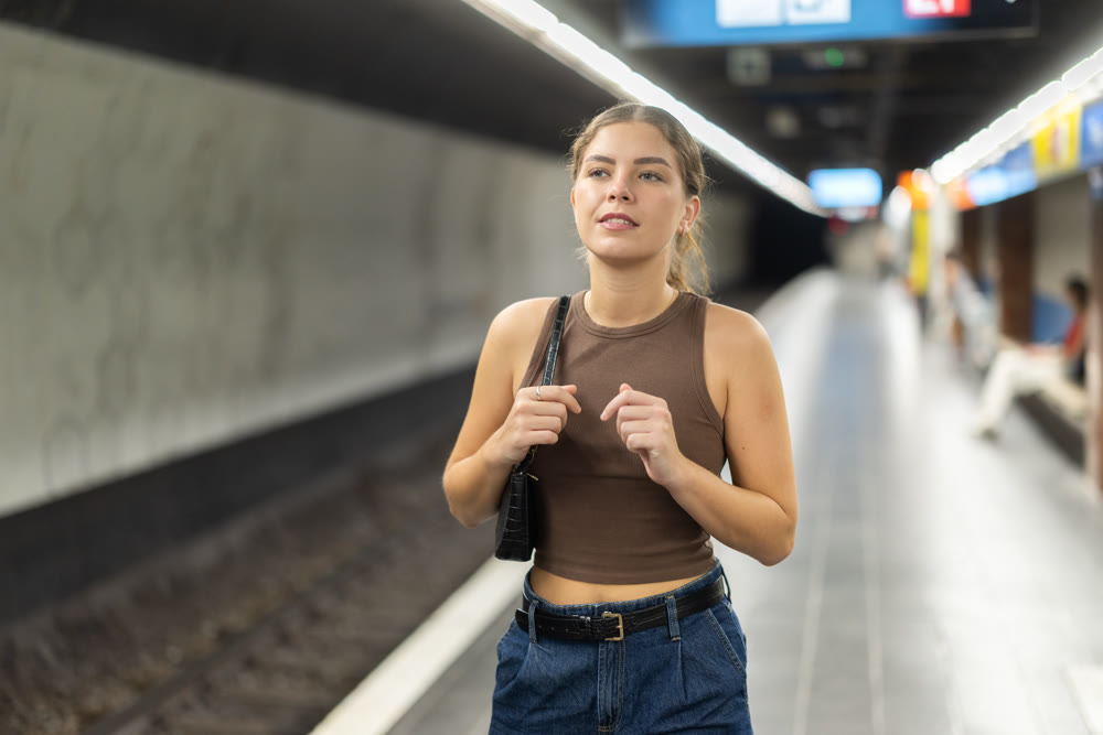 Young woman at metro station is waiting for train