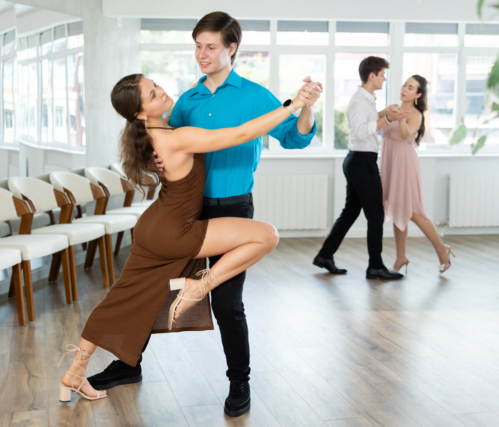 Graceful young duet dancing passionate tango at dance class