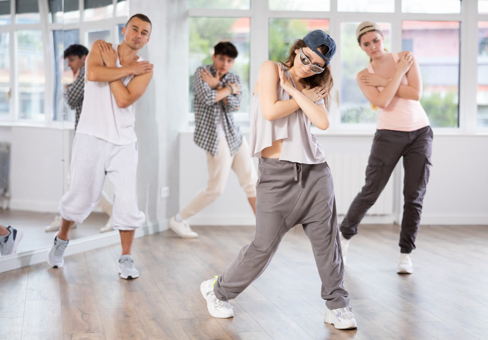 Active group sporty people practicing hip-hop dance in training hall during dancing classes